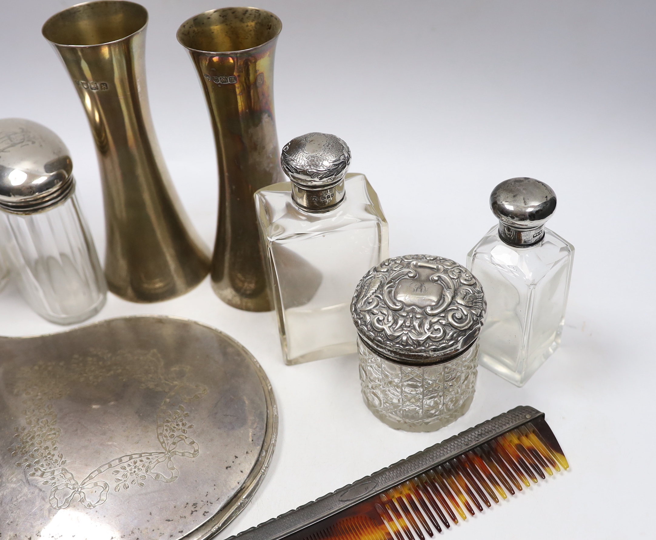 A pair of Edwardian silver waisted spill vase, London, 1907, 15cm, six silver mounted glass toilet jars, a silver mounted hand mirror and comb.